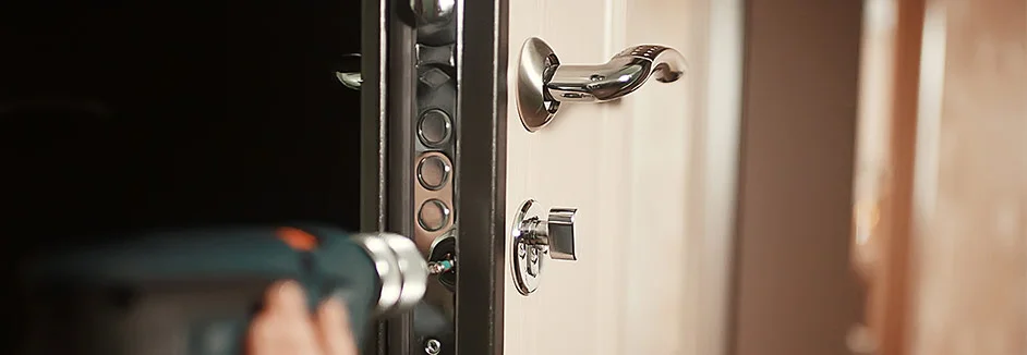 Person montiert Türschloss mit Akkuschrauber